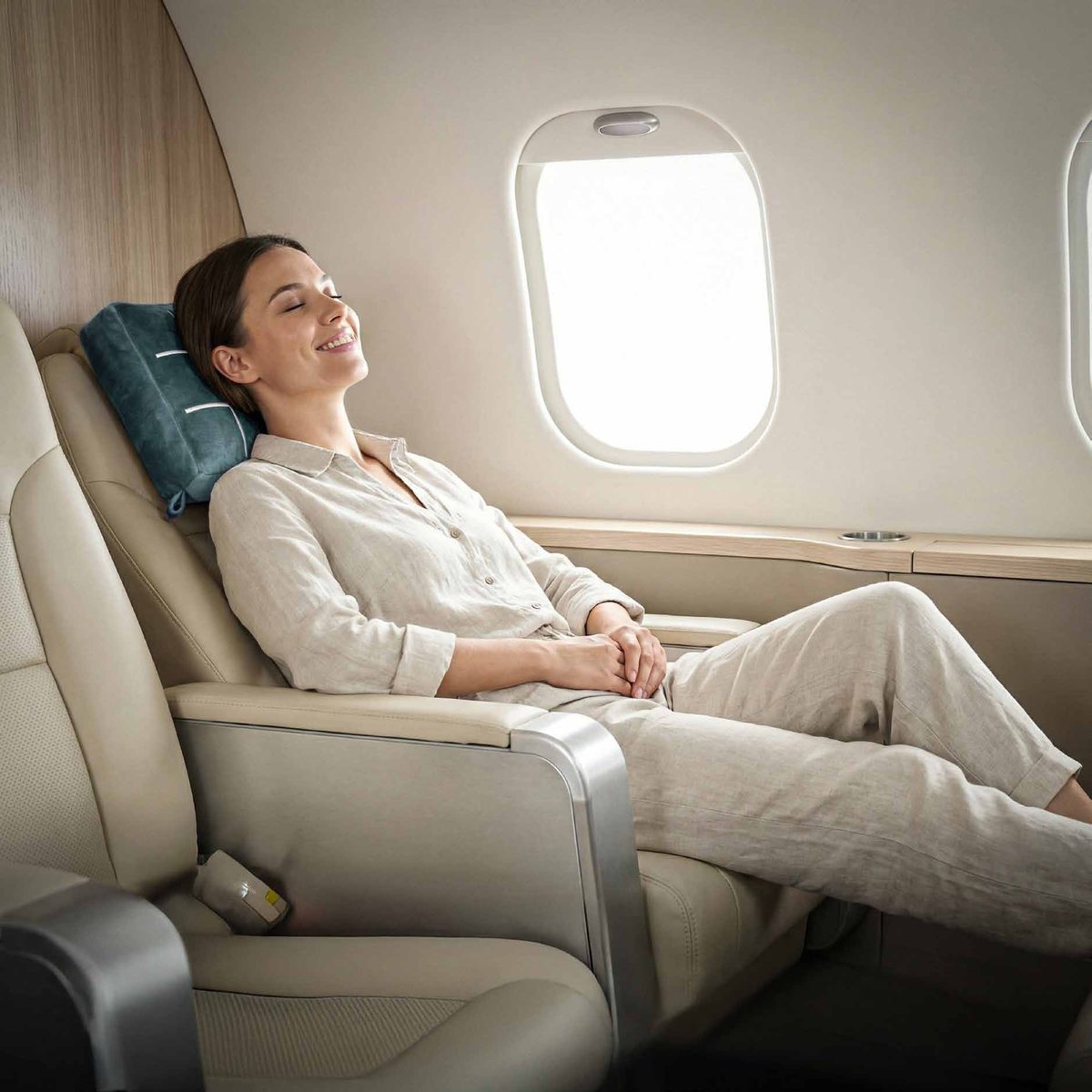 Traveler resting her head on the teal TicTac2Go pillow in a plane seat
