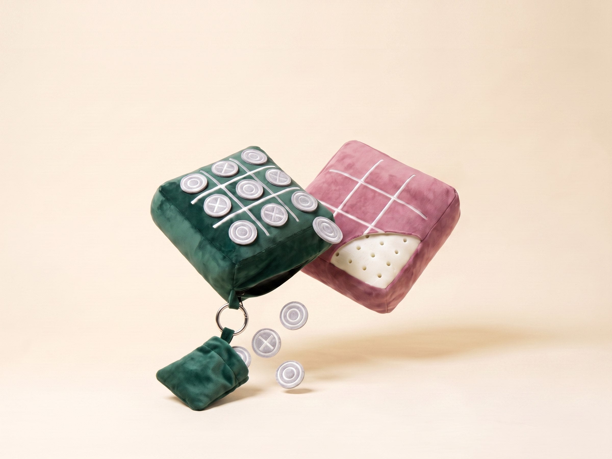Forest Green and Heritage Pink TicTac2Go pillows floating with game pieces and pouch